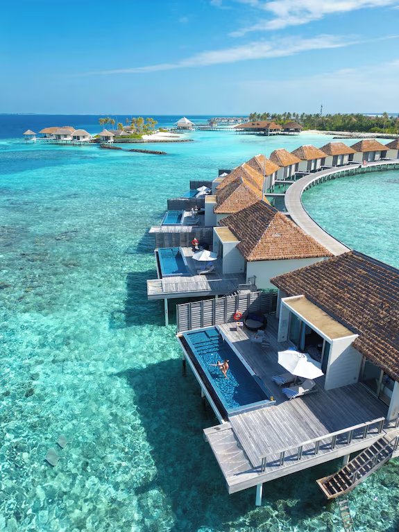 Overwater villas on stilts above a turquoise Maldives lagoon